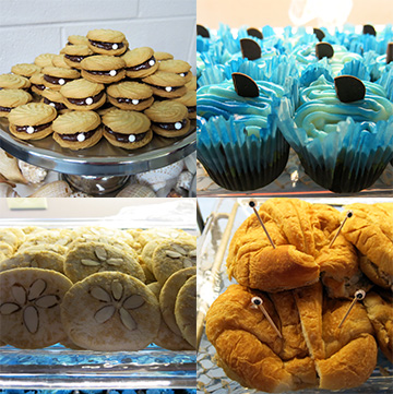 Sea-themed snacks for visitors: top left "oyster" cookies with pearl decorations, top right cupcakes with blue icing and chocolate wafers that look like shark fins.
Bottom left, "sand dollar" cookies; bottom right, croissant sandwiches that look like crabs with toothpicks and wiggly eyes to represent eyestalks.