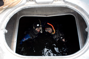Looking down through an opening in the deck of the vessel to the water below.  G.P. and Dan are visible floating in the water.