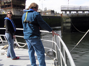 Emma and G.P. at the front railing of the Manta with the lock gates opening behind them