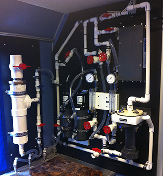 A series of interconnected valves, pipes and sensors mounted on a wall