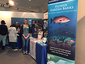 Caitlyn standing next to the FGBNMS display table and banner.