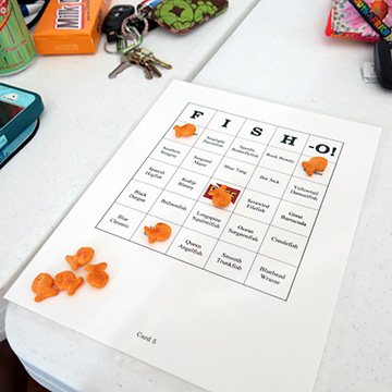 A FISHO playing board (like a BINGO board but with fish names on it) with Goldfish crackers used to mark fish names that have already been called