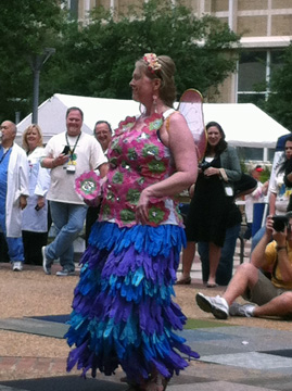 A woman dressed as an earth fairy in a costume made from expired surgical gloves