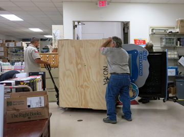 Men moving exhibit crate using pallet jack