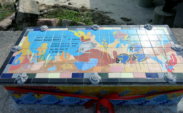 The top of the bench features a tiled design showing tropical reef fish, sea horses, and corals