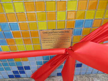 The dedication plaque at the front of the bench says, "Coral Corral - Flower Garden Banks". Artist: Patricia Hagstrom. In Honor of: Galveston's Performing and Visual Arts Organizations and the Individual Artists who add Beauty and Energy to our Island. Special Thanks: Gavleston Commision for the Arts, Galveston County, Artist Boat