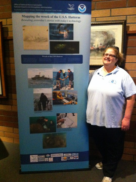 Shelley DuPuy standing next to our new pop-up banner about the USS Hatteras