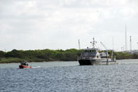 The vessel Manta following a small Coast Guard boat en route to Pier 21.