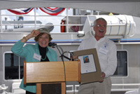 Ted Lillestolen, on the right, presenting Sylvia Earle with a plaque.  Sylvia is pointing out the Flower Garden Banks hat that she is wearing