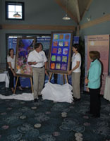 G.P. Schmahl and Jennifer DeBose on either side of a second large, colorful painting depicting deepwater sanctuary species.  Sylvia Earle is standing to the right .  Emma Hickerson is standing to the left rear.