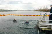 Dan and G.P. floating in the water with just their head and shoulders showing.  Boat dive platform visible to the right.