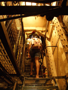 A students climbing a steep set of stairs inside the Battleship Texas.