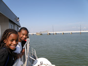 Students on a boat as it approaches a draw bridge that is opening.