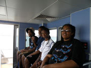 Students sitting on a bench in the pilot house of the R/V Manta.
