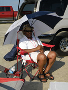 Jimi sitting in a beach chair under an umbrella.