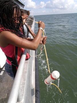 Girls pulling up a niskin bottle from the water after taking a sample.