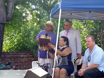 A woman reading a proclamation and holding a microphone.