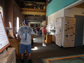 A couple of guests viewing different display cases in the Treasures of NOAA's Ark exhibit.