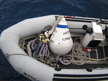 A mooring buoy sitting on the floor of a rigid hull inflatable boat.