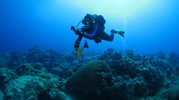 Diver running a tape measure across the reef while navigating to a particular spot.