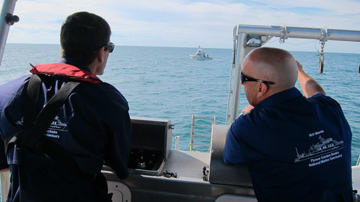 Two men standing at the stern control station of the R/V Manta.