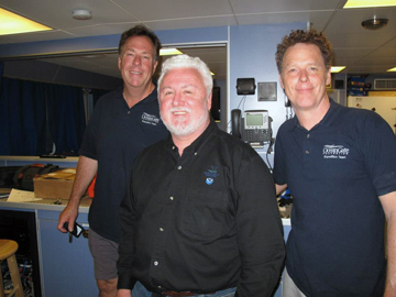 Three men standing in the dry lab of R/V Manta.