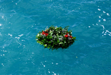 Memorial wreath of greens floating on the water.