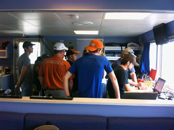 Students gathered around a computer in the dry lab of R/V MANTA