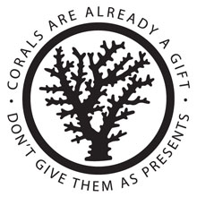 Silhouette of a branching coral enclosed in a black circle. Around the circle it says Corals Are Already a Gift, Don't Give them as Presents.