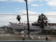 A large boat sitting upright alongside the highway in Galveston