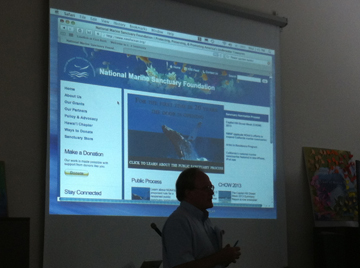 GP silhouetted in front of a screen showing information about the National Marine Sanctuary Foundation