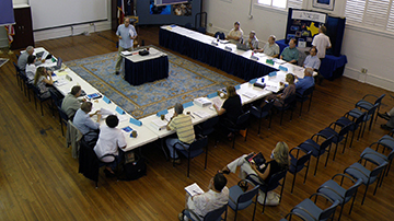Council members seated around a u-shaped table during a meeting