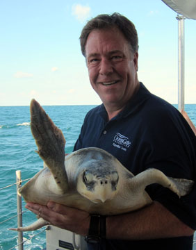 A man holds a sea turtle ready for release