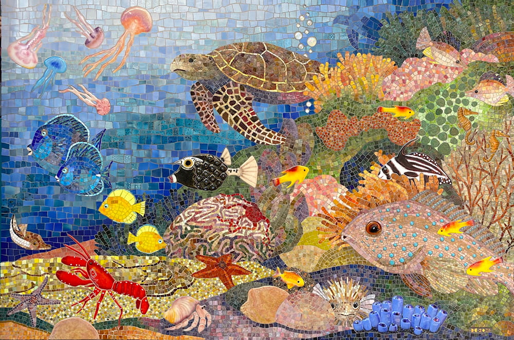 A colorful tile and glass mosaic mural of a coral reef, including corals, fish, jellyfish, a sea turtle, sea stars, a lobster, a hermit crab, sponges, and algae.