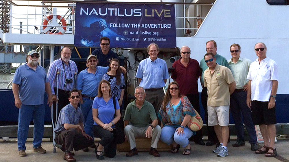 Council members standing in front E/V NAUTILUS, a ship docked in Galveston