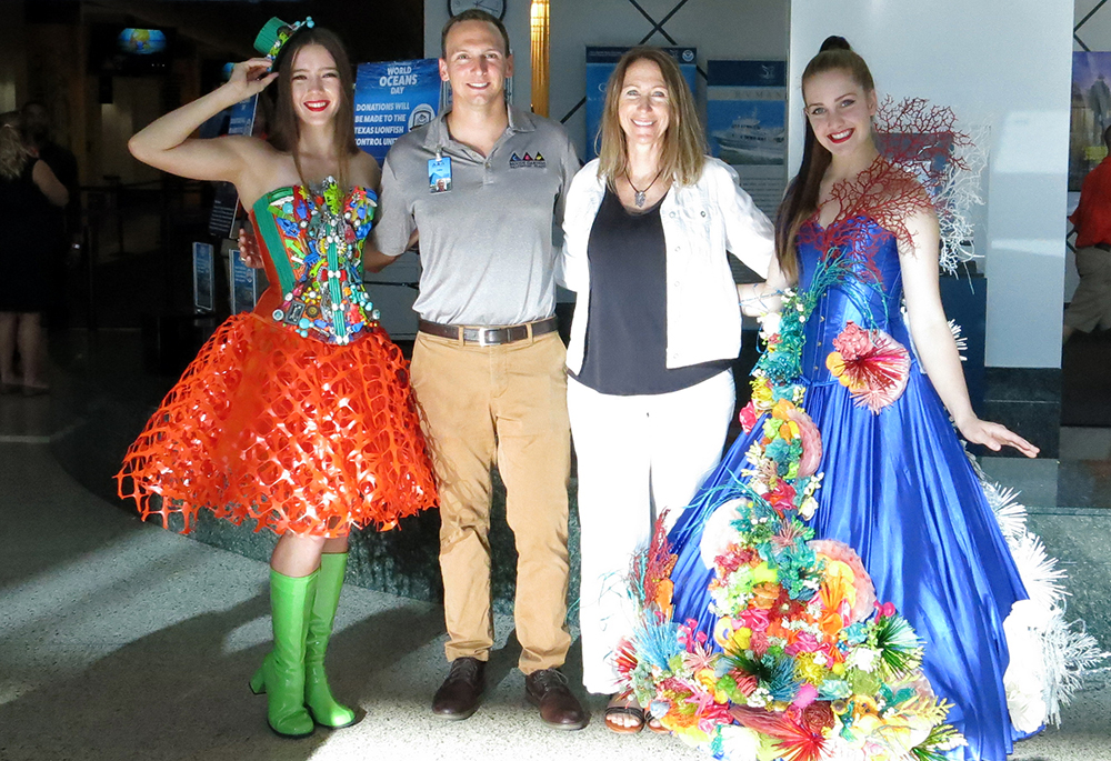 Jake posing with Emma Hickerson and two models wearing colorful dresses representing conservation movies.